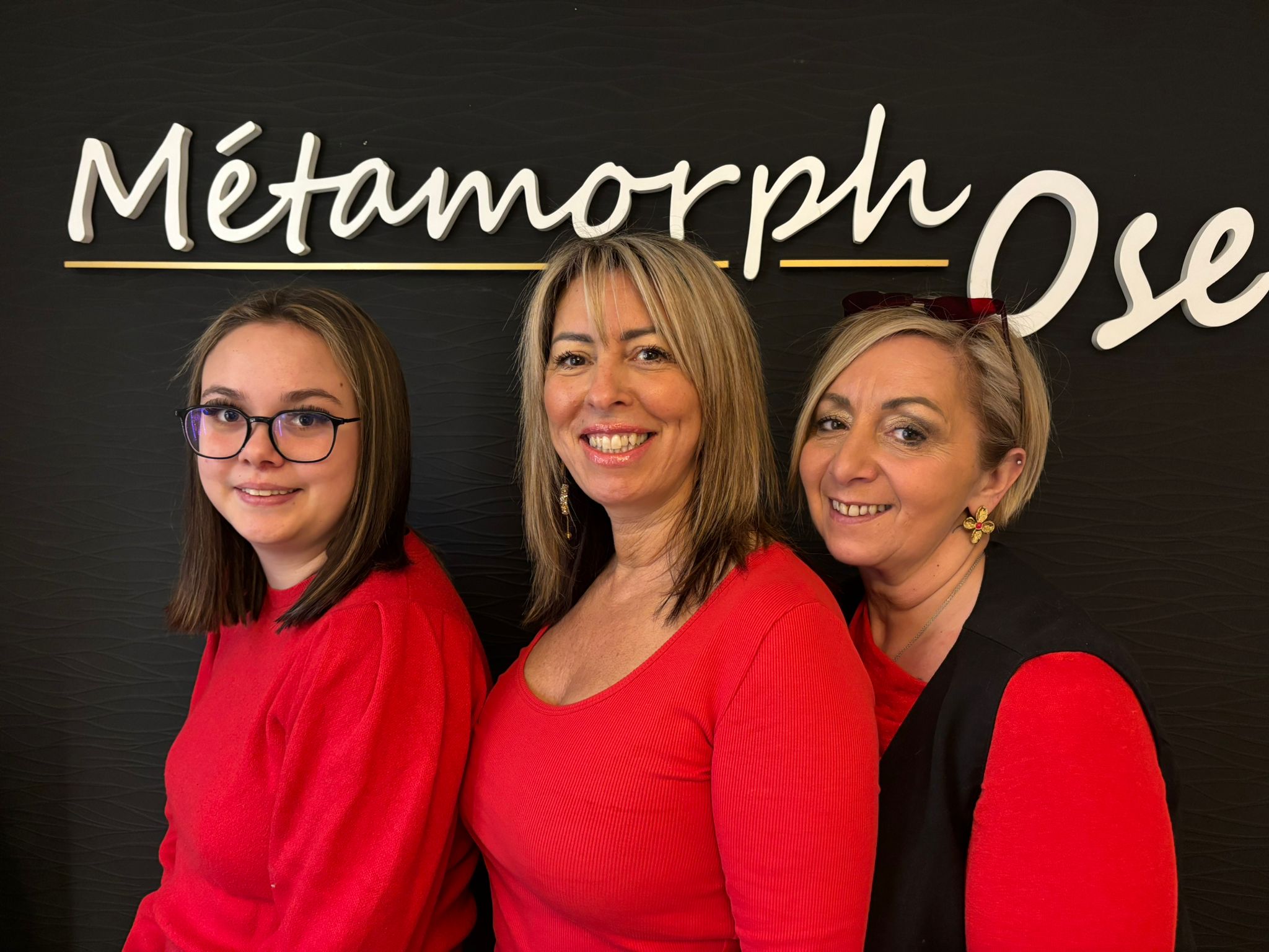 L'équipe Métamorphose : Cathy et ses collaboratrices devant l'enseigne du salon